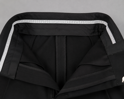 Close-up of boys black Standard Ballroom dance trousers with structured waistband, front pleats, satin side stripe and Diamond Fashion branding