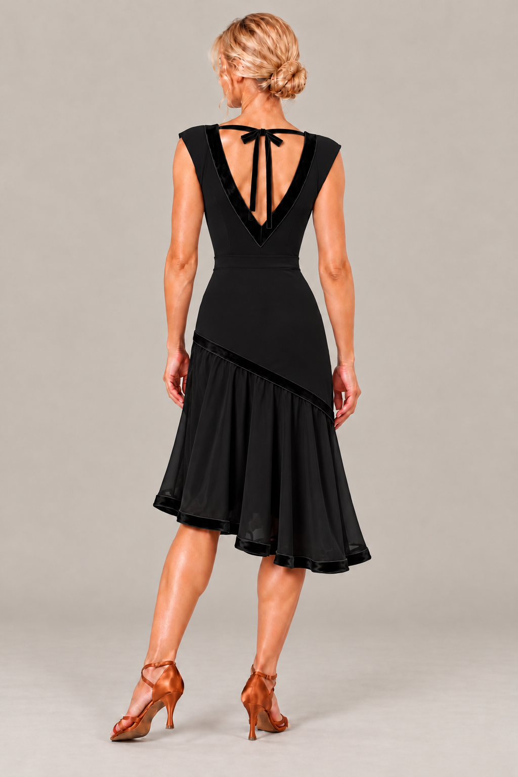 Back view of a black dance bodysuit with a deep V-back and velvet ties, paired with a flowing lined midi skirt.