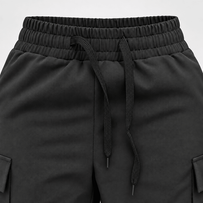 Close-up of Diamond Fashion black dance trousers showing the elasticated waistband, adjustable drawstring and side pockets.