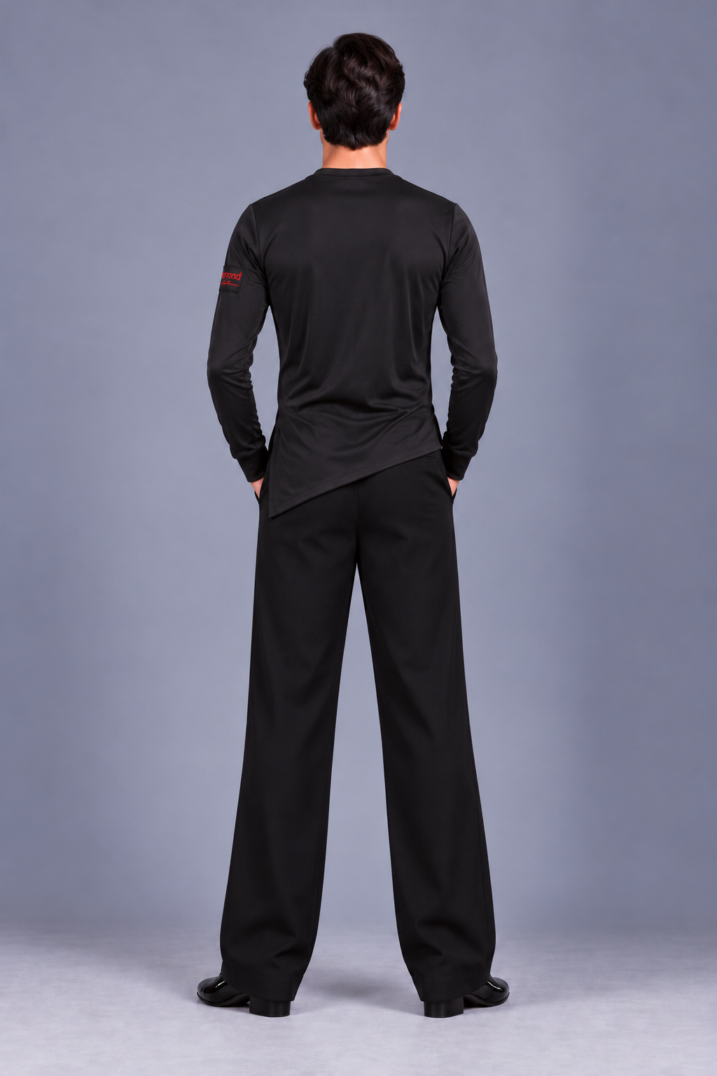 Back view of Diamond Fashion men’s black wide-leg dance trousers and fitted dance top with an asymmetric hem.