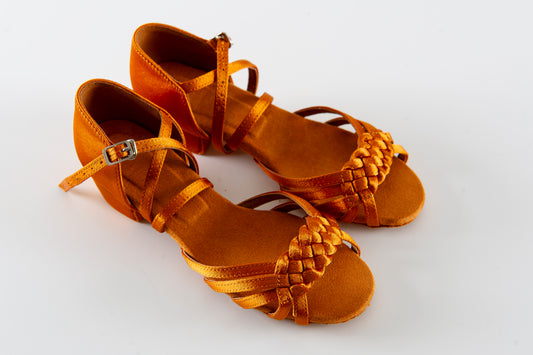 Tan ballroom and Latin dance shoes for girls with braided straps and suede sole, photographed on a light background
