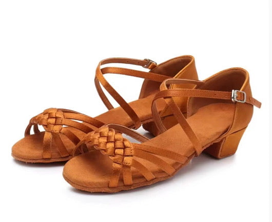 Tan ballroom and Latin dance shoes for girls with braided straps and suede sole, photographed on a light background